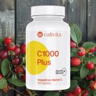 Calivita C 1000 Plus bočica sa 100 tableta vitamina C s postepenim otpuštanjem okružena svježim plodovima šipka na rustikalnoj drvenoj pozadini