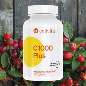 Calivita C 1000 Plus bočica sa 100 tableta vitamina C s postepenim otpuštanjem okružena svježim plodovima šipka na rustikalnoj drvenoj pozadini