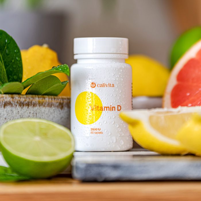 Calivita Vitamin D 2000 IU bočica sa 60 tableta okružena svježim citrusima limun limeta grejp i zelenim listovima na mramornoj podlozi prirodni vitamin za imunitet zdravlje kostiju