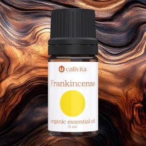 CaliVita organsko eterično ulje tamjana (Frankincense) od 5 ml na drvenom teksturiranom pozadini, s bijelom etiketom, žutim krugom i crnim čepom, za meditaciju i opuštanje