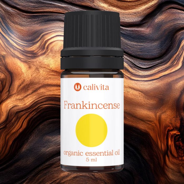 CaliVita organsko eterično ulje tamjana (Frankincense) od 5 ml na drvenom teksturiranom pozadini, s bijelom etiketom, žutim krugom i crnim čepom, za meditaciju i opuštanje
