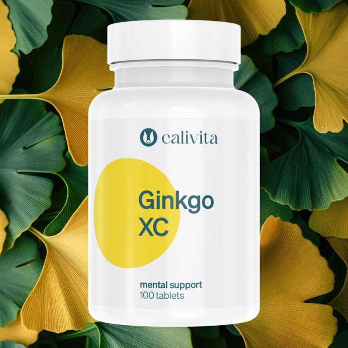 Calivita Ginkgo XC bijela bočica s 100 tableta okružena prirodnim listovima ginka u žuto-zelenim tonovima